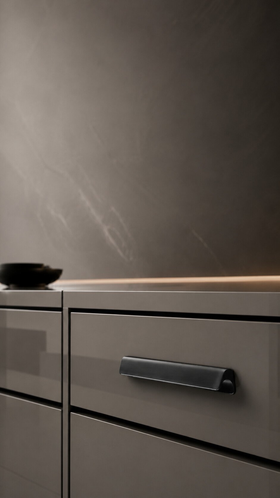 Luxury close-up of a glossy grey wardrobe drawer fitted with a sleek Mello handle